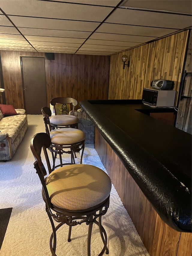 bar featuring a drop ceiling, wood walls, carpet floors, and pool table