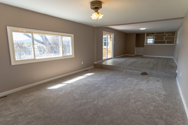 empty room featuring baseboards and carpet floors
