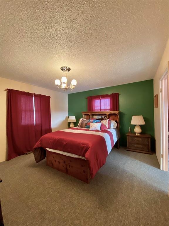 bedroom with a chandelier, carpet, and a textured ceiling