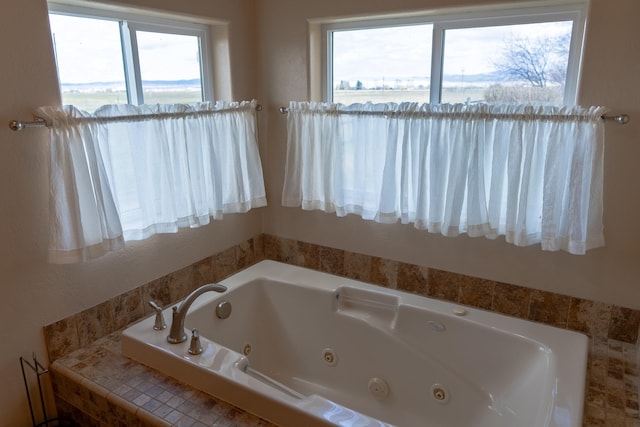 bathroom featuring a wealth of natural light and a tub with jets