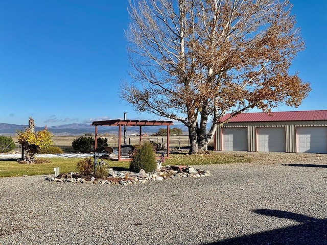 view of yard with a mountain view and a garage