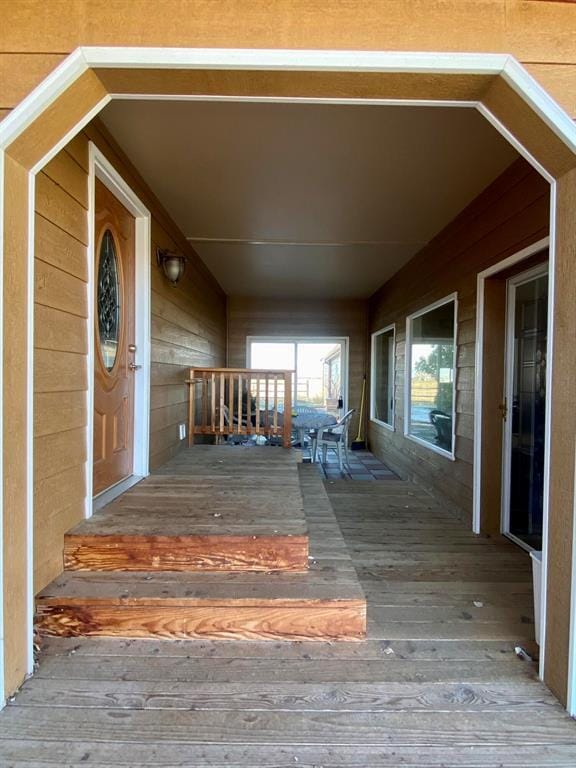 entrance to property with outdoor dining area and a deck