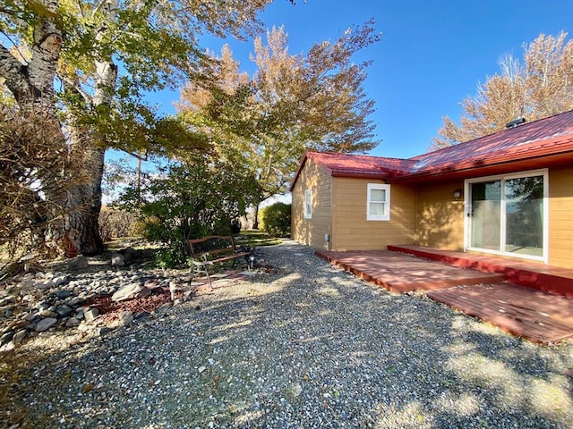 view of side of home featuring a deck and metal roof