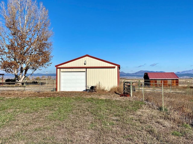 detached garage featuring fence and a mountain view