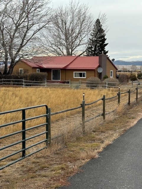 view of front facade featuring metal roof, fence, and a mountain view