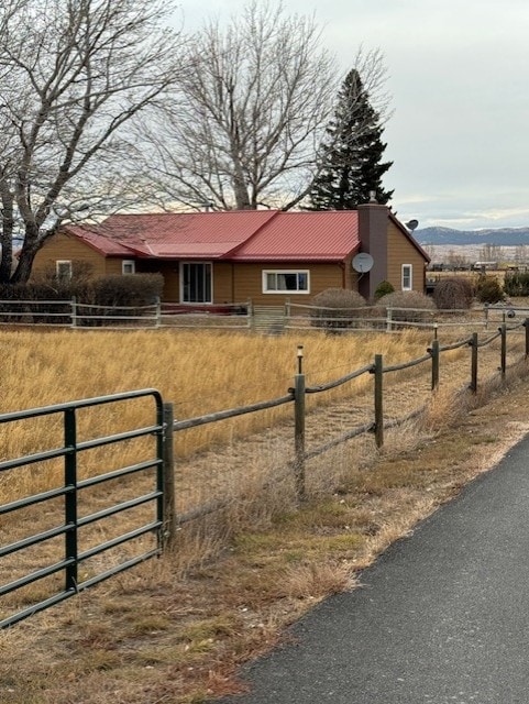 view of home's exterior featuring metal roof, fence, and a mountain view