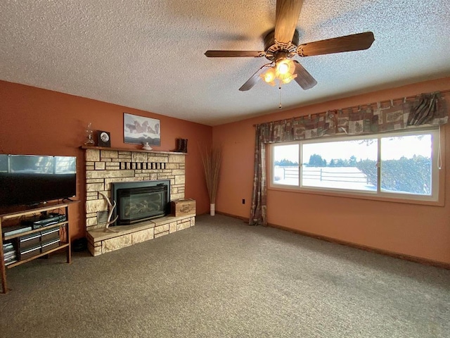 carpeted living room featuring ceiling fan, a stone fireplace, and a textured ceiling