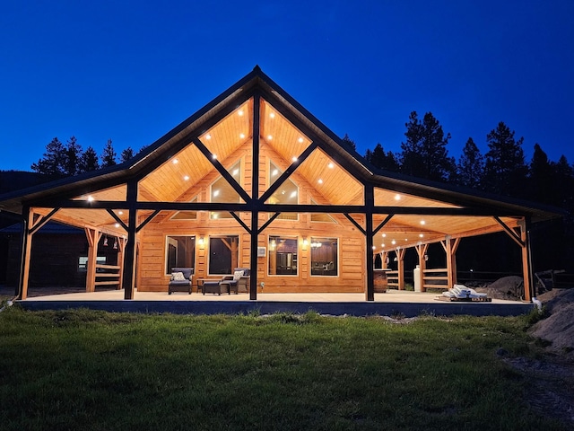 back house at night featuring a lawn