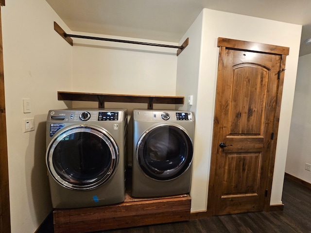 clothes washing area featuring washer and clothes dryer and dark hardwood / wood-style flooring