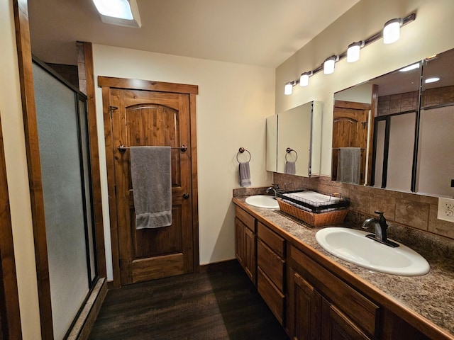 bathroom featuring tasteful backsplash, vanity, an enclosed shower, and hardwood / wood-style flooring