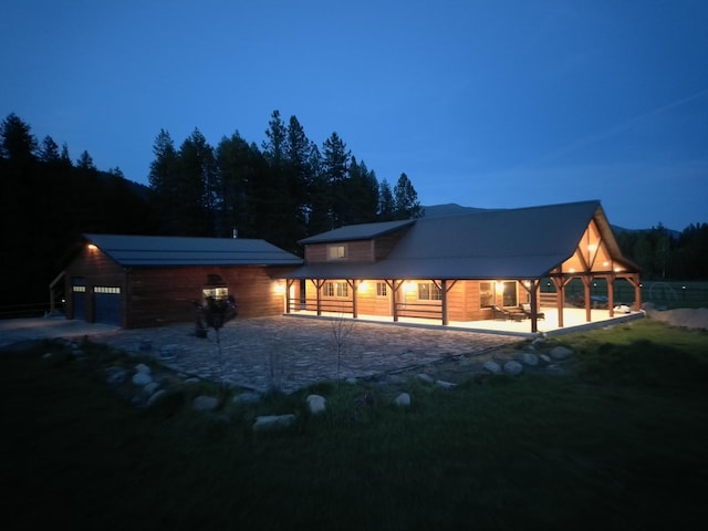 back house at dusk featuring a garage