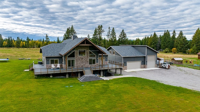 view of front facade featuring an outbuilding, a front lawn, a garage, and a deck