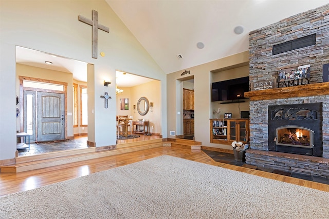 unfurnished living room featuring a fireplace, hardwood / wood-style floors, and high vaulted ceiling