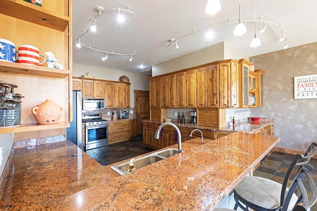 kitchen with light stone countertops, sink, pendant lighting, a breakfast bar area, and appliances with stainless steel finishes