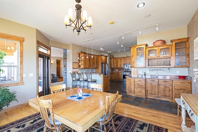 dining room with dark hardwood / wood-style flooring and an inviting chandelier