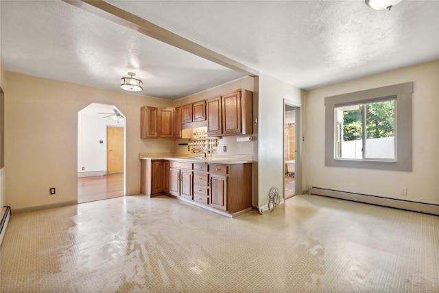 kitchen featuring ceiling fan and a baseboard heating unit