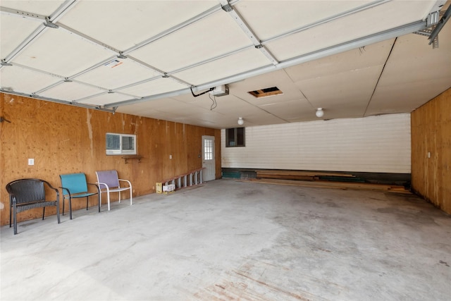 garage with wooden walls and a garage door opener