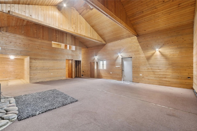 carpeted spare room with beam ceiling, wood walls, high vaulted ceiling, and wood ceiling