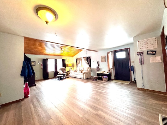 unfurnished living room featuring visible vents and wood finished floors