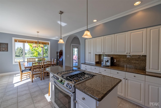 kitchen with decorative light fixtures, dark stone countertops, white cabinetry, and stainless steel range with gas stovetop