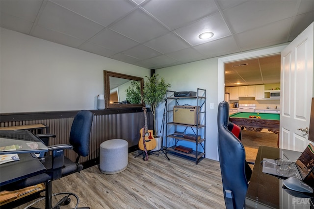 home office featuring light wood-type flooring and a drop ceiling