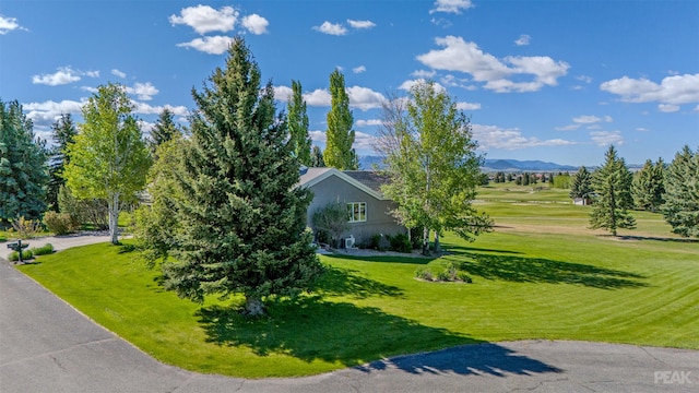 view of side of home featuring a mountain view and a lawn