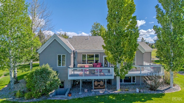 rear view of house featuring a wooden deck and a yard