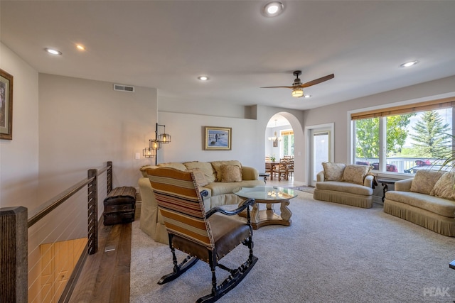 carpeted living room with ceiling fan