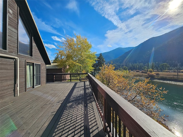 wooden deck with a water and mountain view