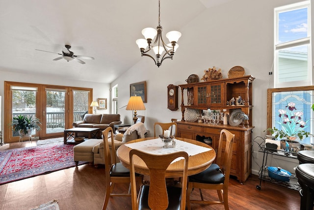 dining room featuring ceiling fan with notable chandelier, dark hardwood / wood-style floors, and vaulted ceiling