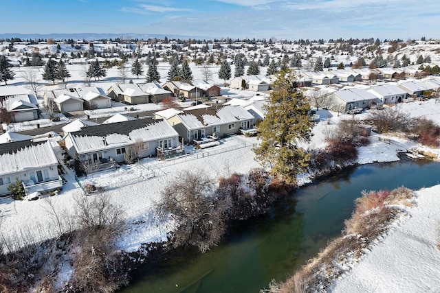 snowy aerial view featuring a water view