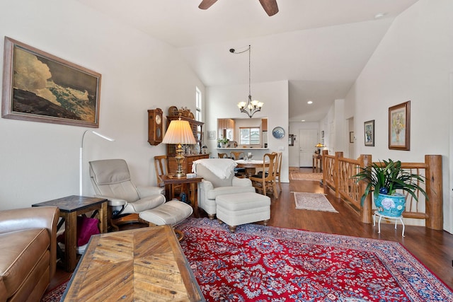 living room with dark wood-type flooring, high vaulted ceiling, and ceiling fan with notable chandelier