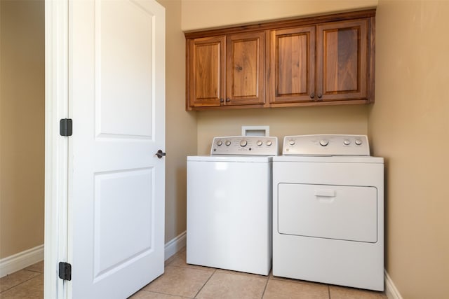 laundry area with light tile patterned flooring, cabinets, and independent washer and dryer