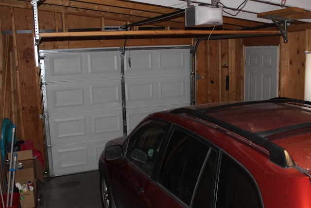 garage featuring wood walls and a garage door opener