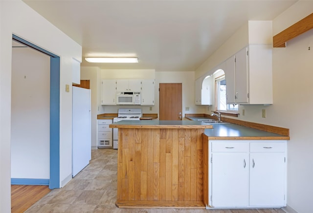 200 N Ave W, Missoula, MT 59801 - kitchen featuring a sink, white appliances, baseboards, white cabinets, and a peninsula