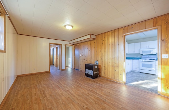 unfurnished room featuring light hardwood / wood-style floors and wooden walls