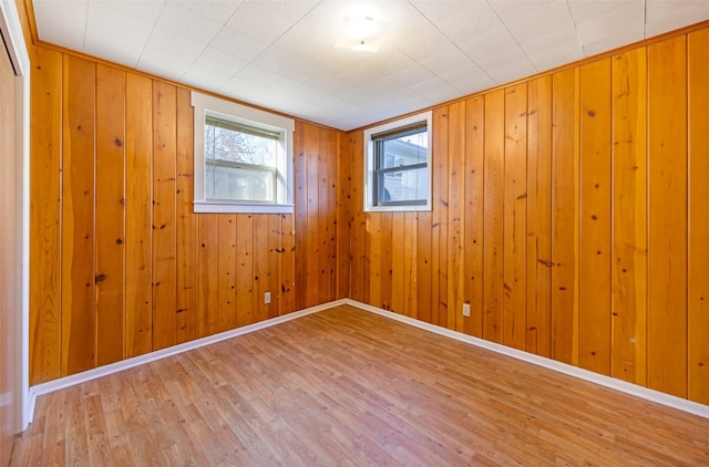 spare room featuring hardwood / wood-style floors and wood walls