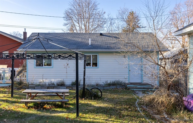 rear view of house featuring a yard