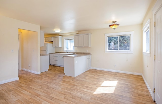 200 N Ave W, Missoula, MT 59801 - kitchen with baseboards, a peninsula, light wood finished floors, and freestanding refrigerator
