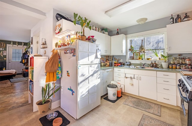 kitchen with white appliances, white cabinetry, and sink