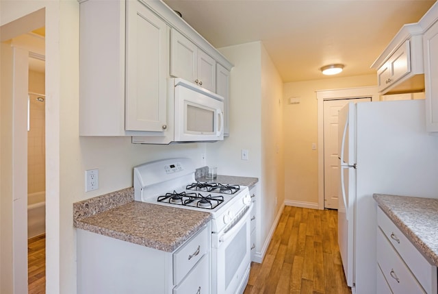 200 N Ave W, Missoula, MT 59801 - kitchen featuring white cabinets, baseboards, white appliances, and light wood-type flooring