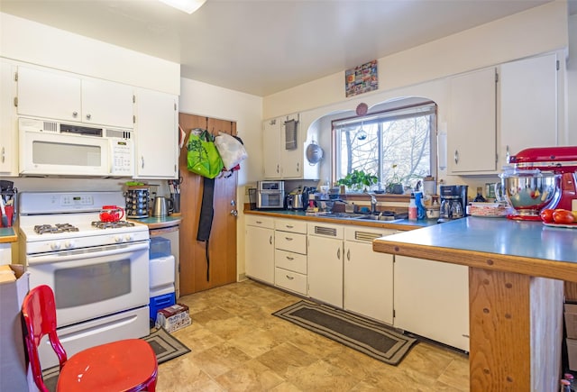 kitchen featuring white cabinets, white appliances, and sink