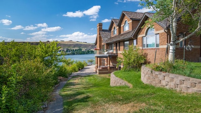 exterior space featuring a water view and a lawn