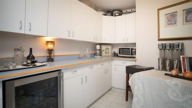 kitchen featuring white cabinets and beverage cooler