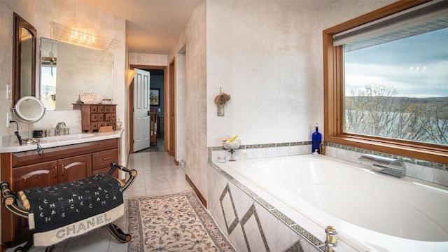 bathroom featuring tile patterned flooring, vanity, and a relaxing tiled tub