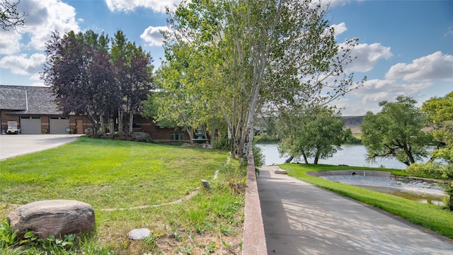 view of front of property featuring a water view and a front lawn