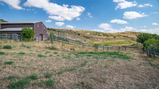 view of yard with a mountain view, a rural view, and an outbuilding