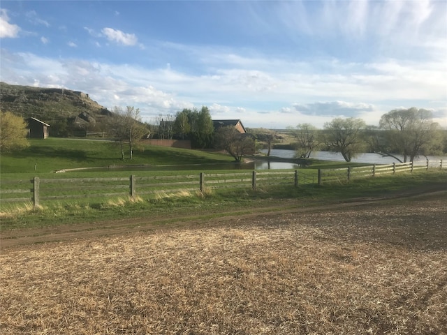 view of yard with a rural view and a water view