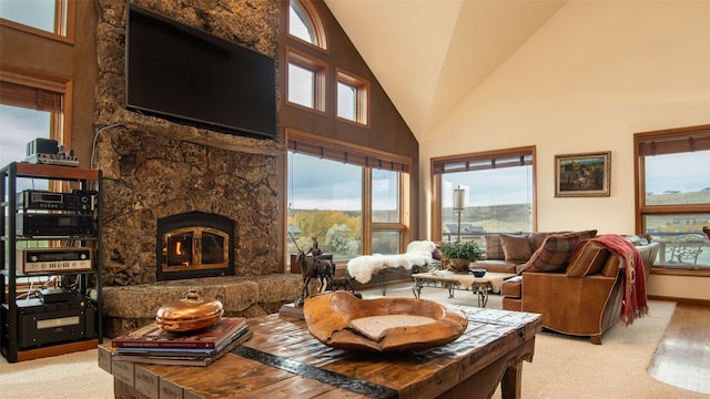 living room with light carpet, high vaulted ceiling, and a stone fireplace