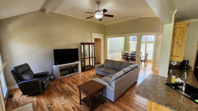 living room with decorative columns, vaulted ceiling with beams, ceiling fan, and light hardwood / wood-style floors